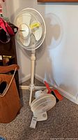 Pedestal fan, tabletop fan, dustpan and brush visible