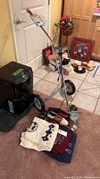 Overall lot showing golf pull cart, shoes, clothing and other items