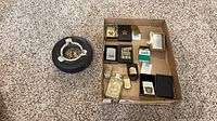 Overview of box containing multiple lighters and ashtray