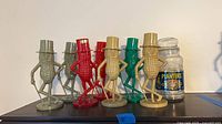 Grouping of seven Mr. Peanut banks in assorted colors alongside Planters glass jar