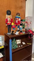 Overall lot showing wooden sled, four loose nutcrackers, boxed nutcracker, ceramic tree