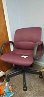 Front view of burgundy upholstered swivel chair on caster base
