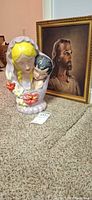 Front view of ceramic Madonna planter and framed Jesus print