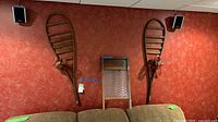 Two snowshoe frames and washboard on wall