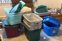 Group of assorted storage bins stacked in living room