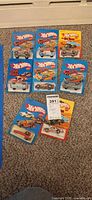 Front view of eight sealed Hot Wheels blister packs on carpet