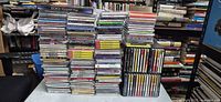 Wide shot of three tall stacks of CDs on table, showing volume