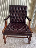 Front view showing tufted leather seat and back, wood frame, nailhead trim