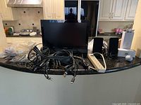 Front view of VIZIO display with speakers, power strip and assorted cables