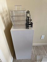 group shot showing pedestal, stacked acrylic organizers, black stands and ornate easel