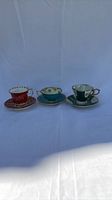 Front view of three mismatched teacup-and-saucer sets