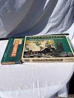 Billionaire and Scrabble board games side by side, full view of box tops