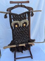 Full view of macramé owl wall hanging on display stand