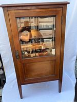 Front view of mahogany cabinet with glazed door and brass escutcheon