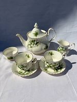 Entire tea set displayed: teapot with lid, creamer, two cups and two saucers