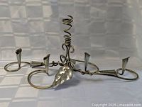 Full view of the silver-plated centerpiece candle holder showing spiral center, four arms, and leaf accent