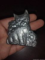 Front view of aluminum cat candle holder showing detailed relief and size reference