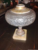 Front view of Marvel glass oil lamp showing embossed reservoir and base