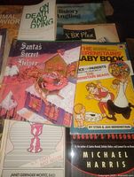 Group of books showing Santa's Secret Helper, The Berenstains' Baby Book, On Death and Dying, XBX Plan, others