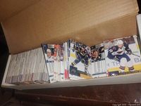 Open cardboard box showing rows of hockey trading cards standing upright