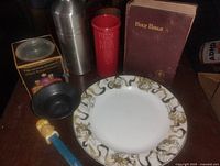 All items grouped: Bible, plate, shaker, tumbler, boxed mug, black dish, PEZ dispenser