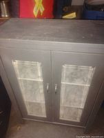 Front view of grey cabinet showing glass doors and shelves