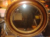Front view of round mirror showing ornate frame and glass