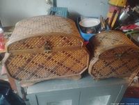 Front view of both wicker boxes showing woven pattern, clasp, size difference