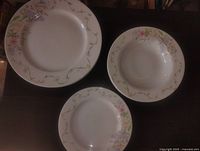 Top view of three Br-adley plates and bowl showing floral pattern