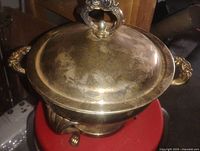 Lidded silver-plated dish showing ornate handles and finial