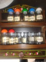 Front view of rack showing top and middle shelves with labeled jars