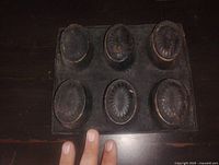 Top view showing six oval molds with dark patina