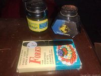 Front view showing the two ink bottles, boxed cocktail forks, and fountain pen