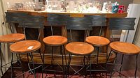 Front view of all six bar stools lined at bar