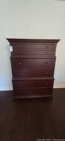Front view of tall five-drawer dresser