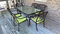 Rectangular metal patio table with six chairs around it on deck