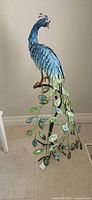 Full view of metal peacock sculpture on stand