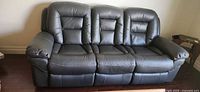 full front view of grey three-seat faux leather recliner sofa