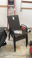 Four stacked patio chairs front view