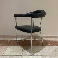 Full frontal angled view of chrome and black upholstered armchair