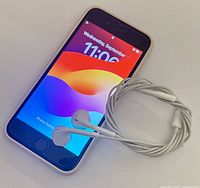 iPhone SE powered on with EarPods coiled beside