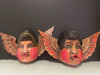 Both carved wooden angel busts side by side