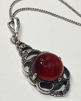 Close-up of pendant with carnelian cabochon in ornate silver setting