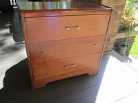 Front view showing full dresser with three drawers and waterfall edges