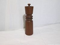Full view of teak pepper mill standing upright