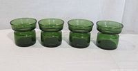Front view of four green glass votive holders