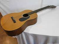 Full view of acoustic guitar showing body, neck, overall wear