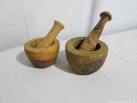 Two assembled wooden mortar and pestle sets