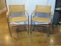 Pair of tan sling chrome cantilever armchairs front view