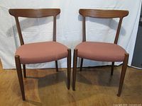Front view of both Skaraborgs teak dining chairs showing overall design and upholstery